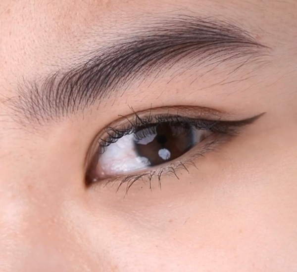 A close up image of a girl's eyebrow and eye, showing hyper realism brows - a style of permanent makeup where the hair-strokes of the eyebrow natural blend in with the natural hairs.